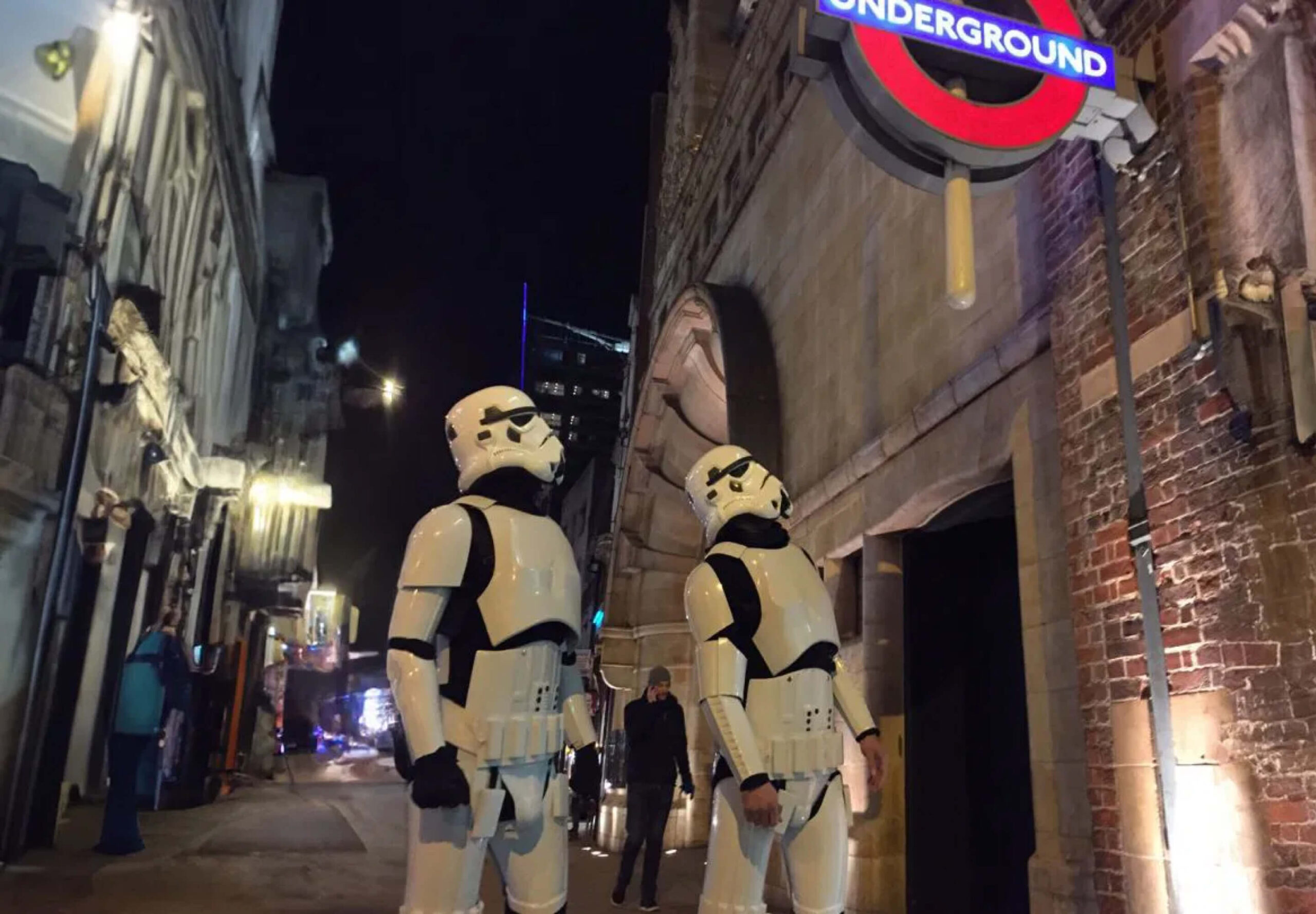 Two KOTA employees looking at a London Underground sign dressed as Storm troopers
